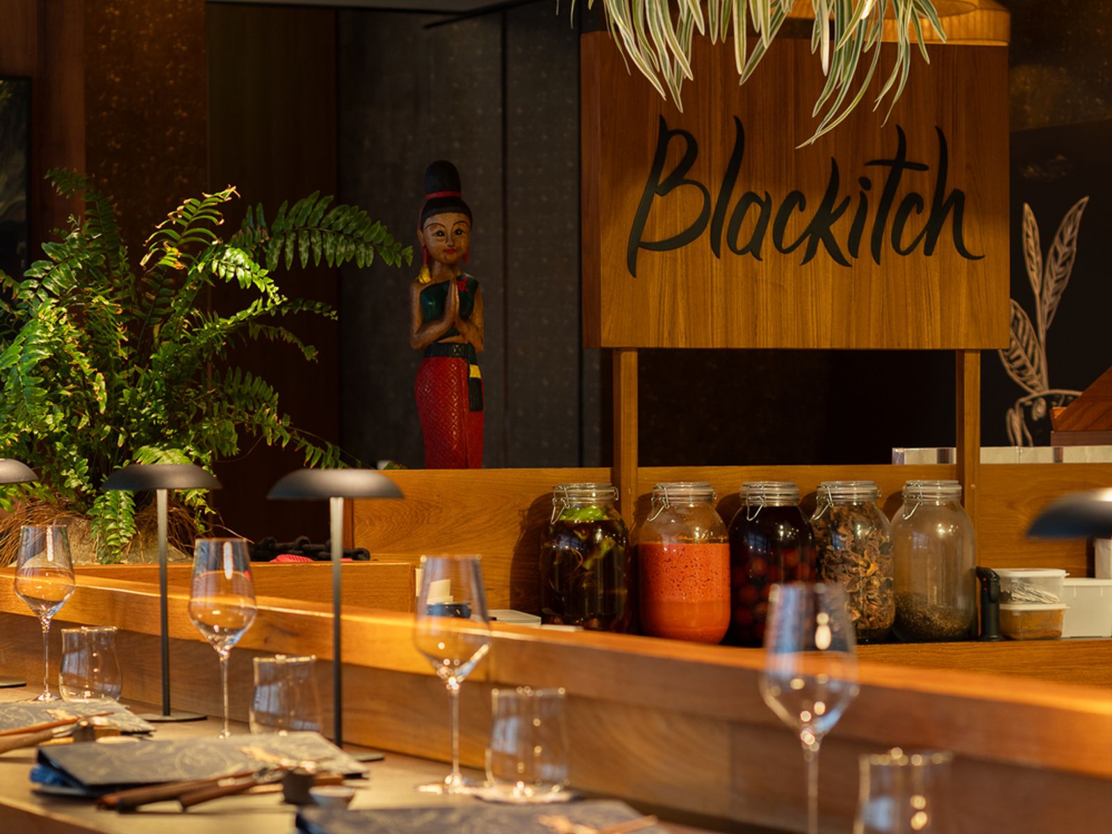 Blackitch 餐厅主厨席，木质吧台、暖光餐位与发酵食材罐陈列